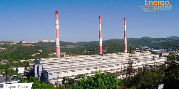 CHP plant with three red and white chimneys among green hills (Vladivostok CHPP-2)