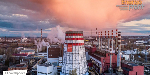 Cooling tower of Izhevskaya CHPP-2 with T Plus logo and chimneys at sunset