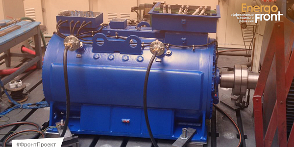 Large blue industrial electric motor on a test bench in a workshop
