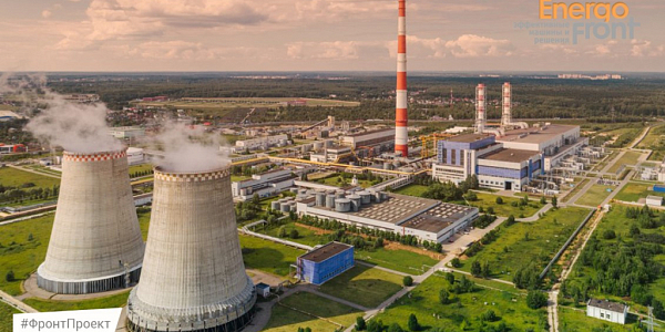 Aerial photo of a thermal power plant with two cooling towers and a striped chimney