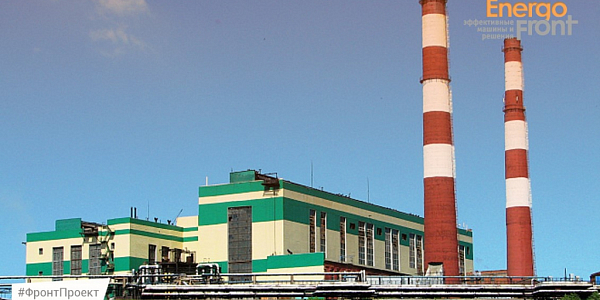 Green and yellow station building and two red and white chimneys