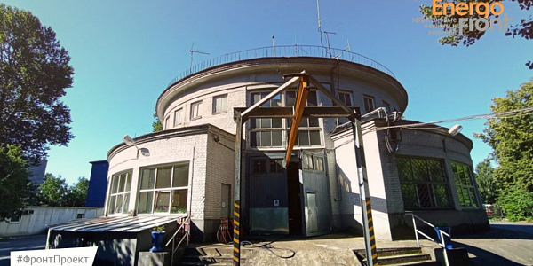 Round two-tier technical building with a yellow frame at the entrance