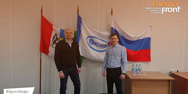 Two men near the flags of the Novosibirsk region, ELSIB and Russia