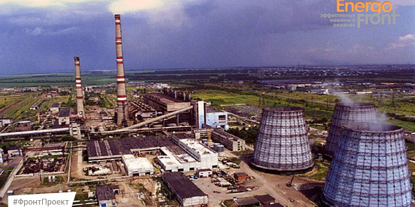 Aerial photo of a thermal power plant with three cooling towers and red and white chimneys under a gloomy sky (Barnaul CHPP-3)