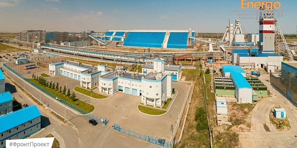 Aerial view of a mining and processing complex with blue roofs and headframes