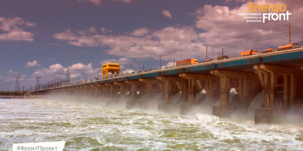 Discharge of water through the spillways of a concrete hydroelectric dam with equipment on the crest