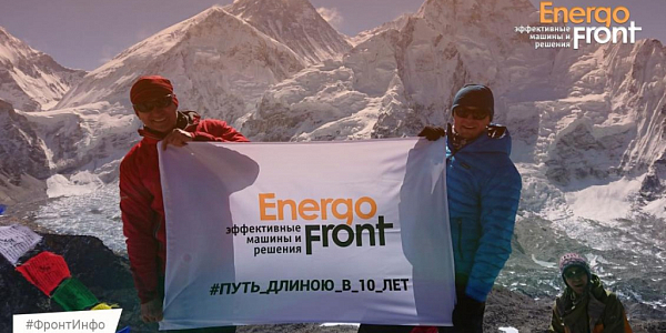 Two climbers with an EnergoFront banner against a background of snowy mountain peaks