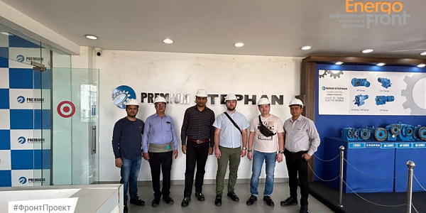 Six men in white helmets at the Premium Stephan stand with industrial gearboxes