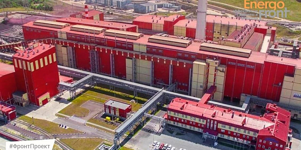 Aerial view of a red and yellow industrial complex with pipeline racks and a parking lot