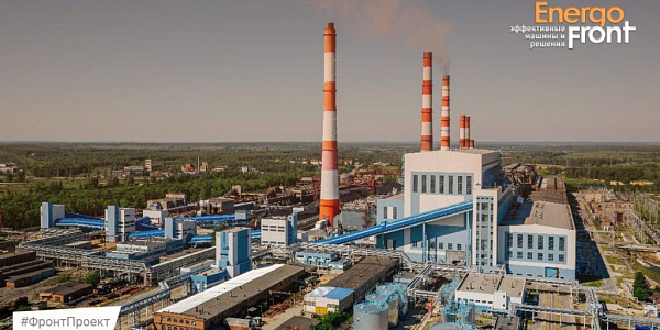 Aerial shot of a power plant with red and white chimneys and blue galleries in the middle of a forest