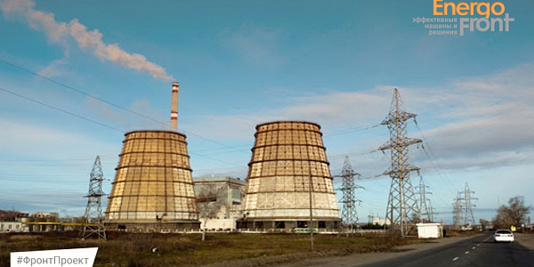 Two hyperboloid cooling towers and a striped chimney near a power line
