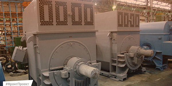 Large gray industrial electric motors in a factory workshop on a concrete floor