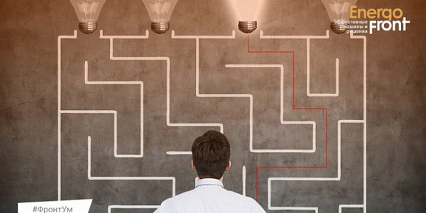 A man with his back to the camera looks at a maze with one burning light bulb