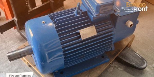 Blue industrial electric motor on a wooden pallet in a warehouse