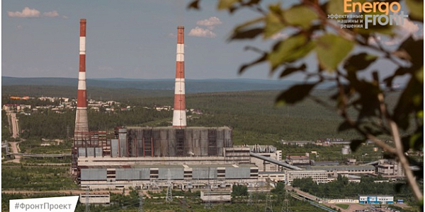 Thermal power plant with two tall chimneys among wooded hills
