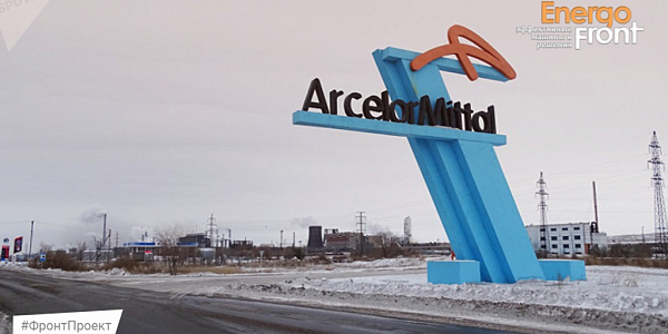 ArcelorMittal winter rack-monument against the background of factory pipes and snow