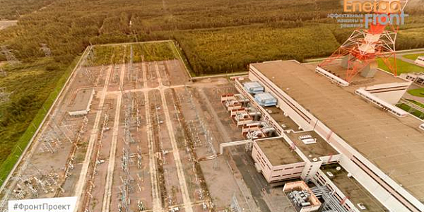 Top view of a substation and an industrial building among the forest at sunset