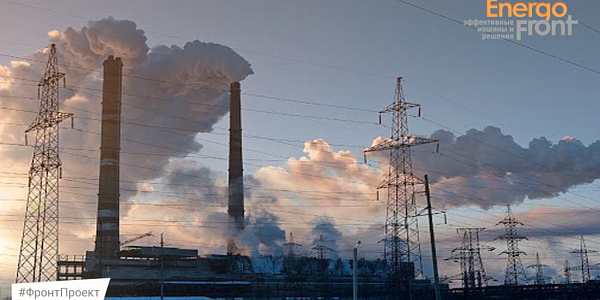 Power plant chimneys and power line pylons in the warm sunset light