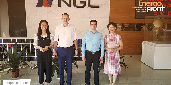 Four employees in the lobby near the NGC logo and EnergoFront branding