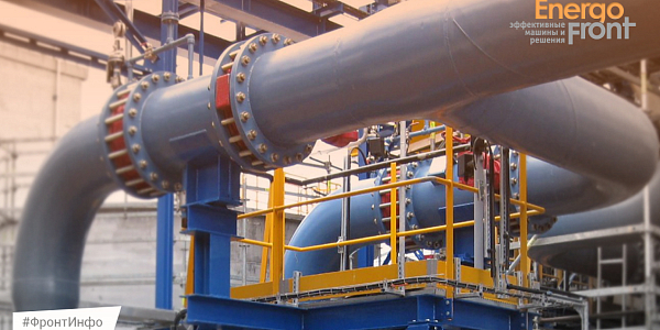 Large blue pipelines on supports with yellow site fences