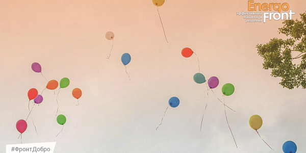 Multi-colored balloons fly into the sky near the crown of a tree, EnergoFront logo
