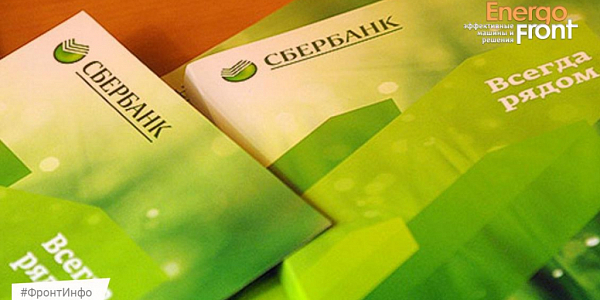 Green Sberbank booklets with the slogan Always nearby on a wooden table
