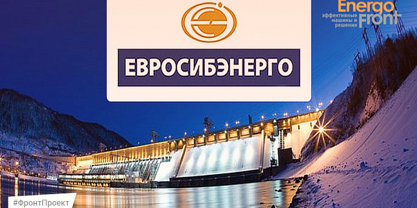 Night illuminated hydroelectric power station against the backdrop of snowy hills with the Eurosibenergo logo