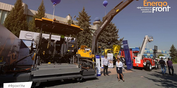 Open exhibition of Volvo equipment: paver excavator and visitors