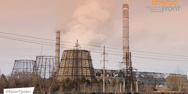 Thermal power plant with cooling towers, smoking chimneys and power lines at a pink sunset