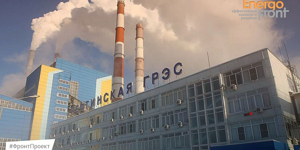 A building with the inscription Reftinskaya State District Power Plant and chimneys with thick white steam