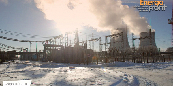 Winter site of thermal power plant with cooling towers, steam and high-voltage equipment